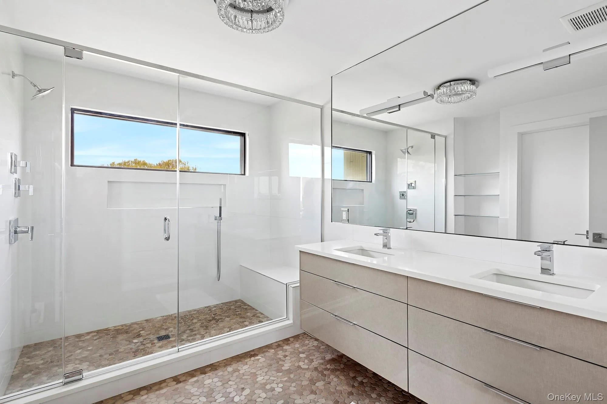 Bathroom featuring a sink, a shower stall, and visible vents