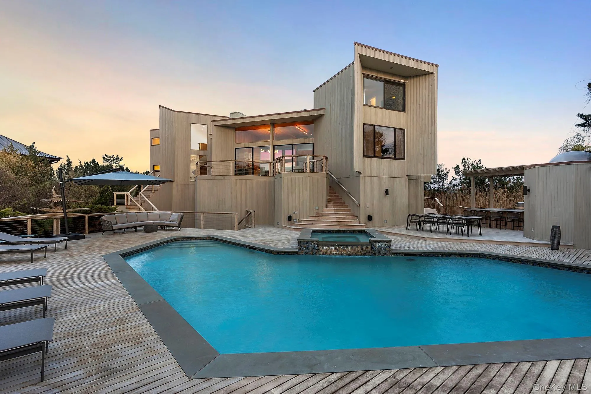 Back of property featuring outdoor lounge area, a pool with connected hot tub, a patio area, stairway, and a wooden deck