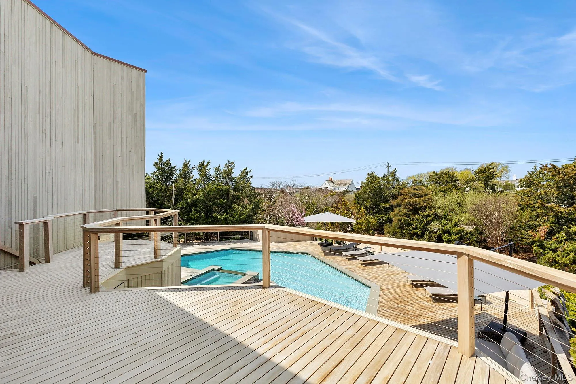 View of swimming pool featuring a deck and a pool with connected hot tub