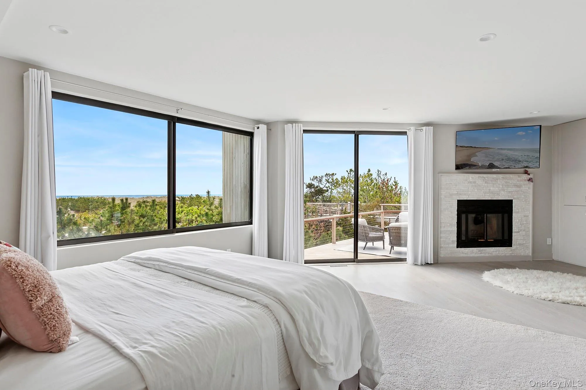 Bedroom with a fireplace, wood finished floors, and access to exterior