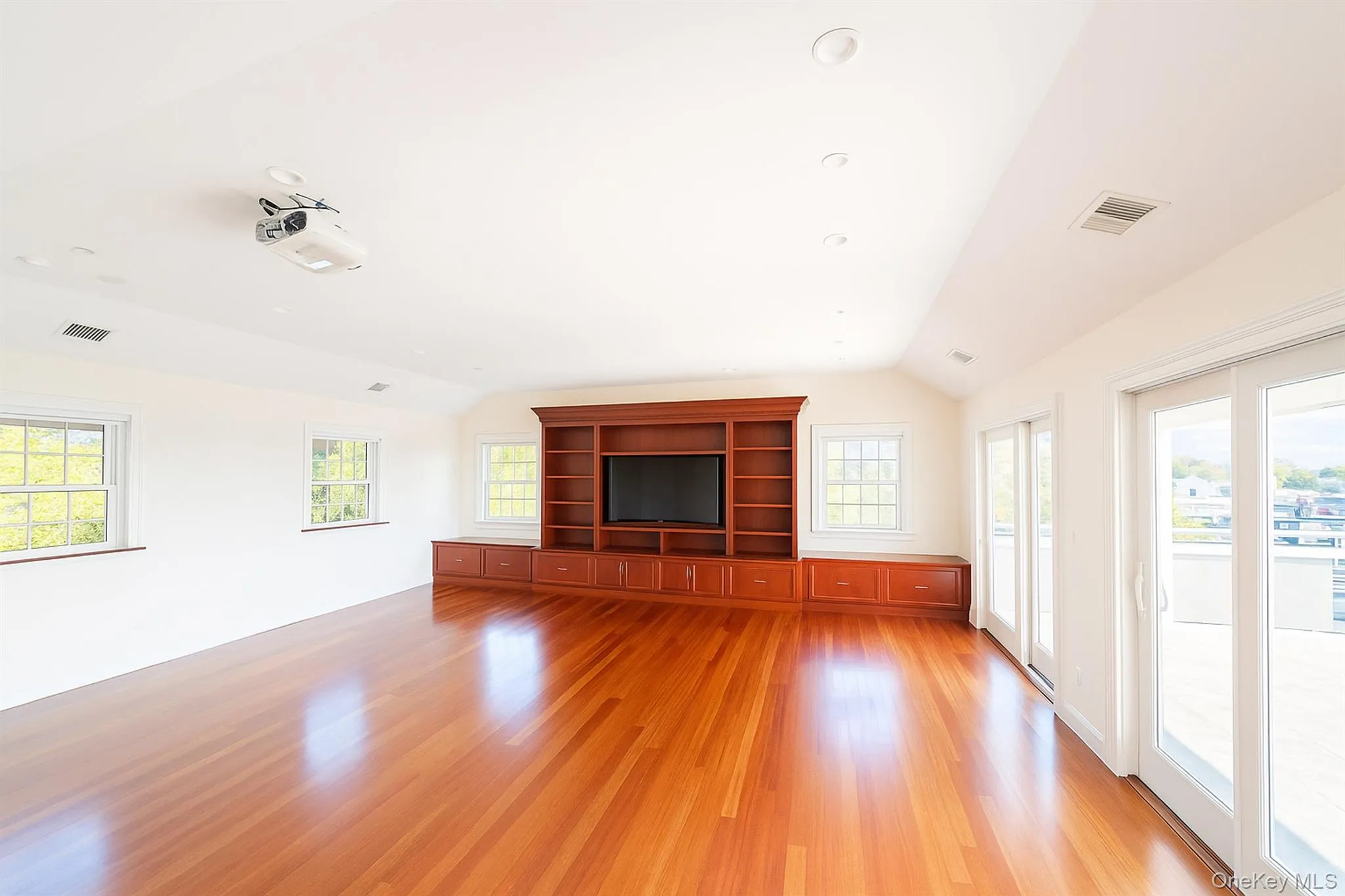 Unfurnished living room with vaulted ceiling, plenty of natural light, light wood finished floors, and recessed lighting Unfurnished living room with vaulted ceiling, plenty of natural light, light wood finished floors, and recessed lighting
