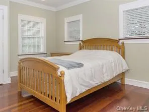 Bedroom with crown molding, baseboards, and wood finished floors Bedroom with crown molding, baseboards, and wood finished floors