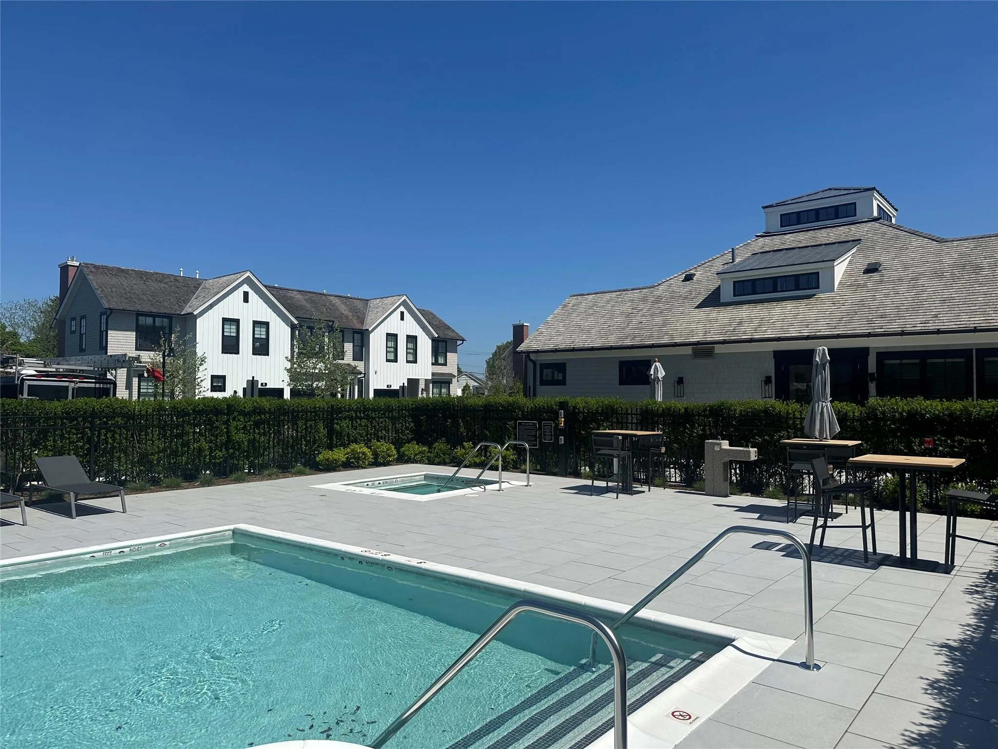 Community pool featuring a community hot tub, a patio area, and a residential view Community pool featuring a community hot tub, a patio area, and a residential view