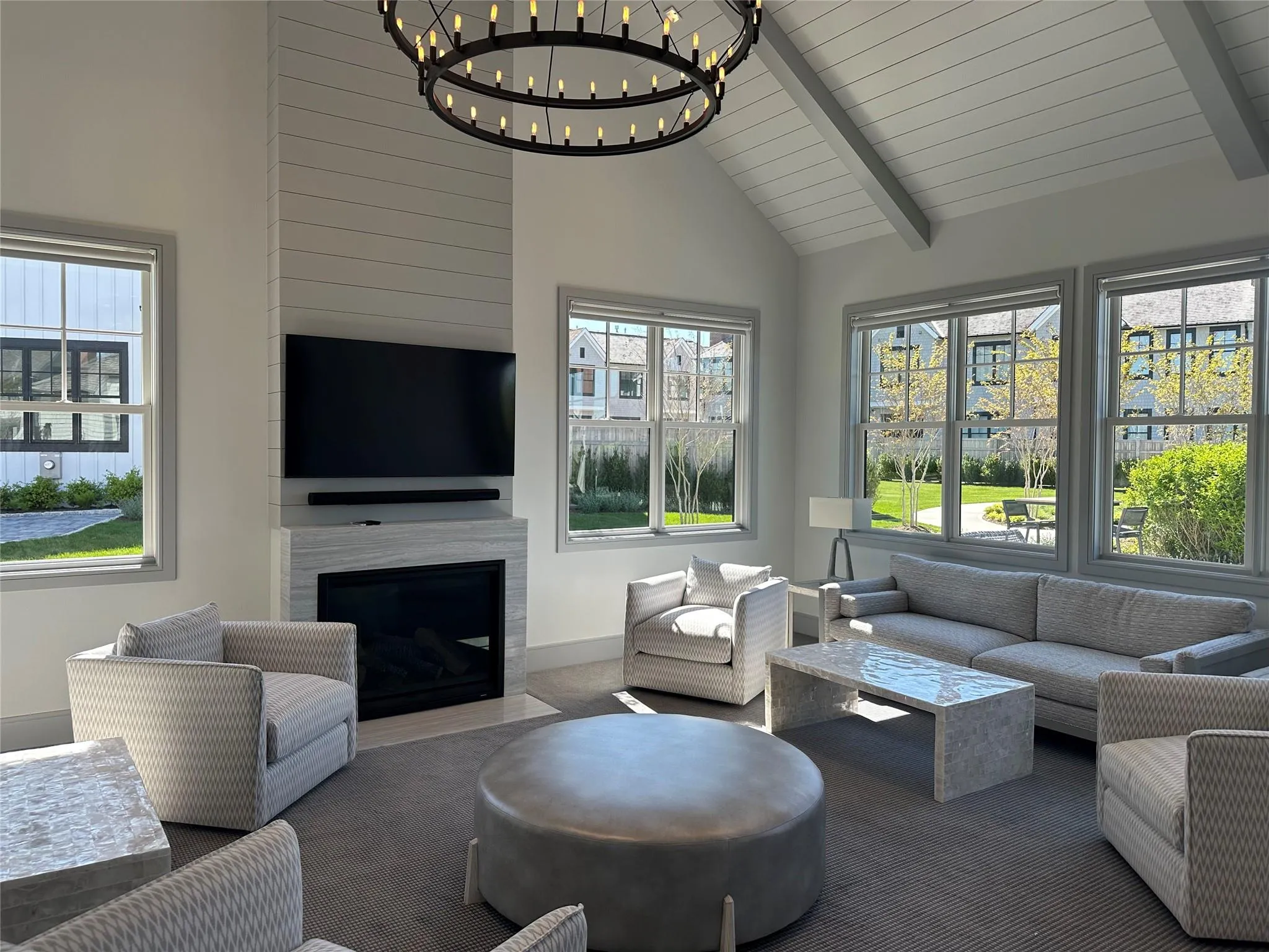 Living area featuring a chandelier, high vaulted ceiling, beamed ceiling, plenty of natural light, and baseboards Living area featuring a chandelier, high vaulted ceiling, beamed ceiling, plenty of natural light, and baseboards