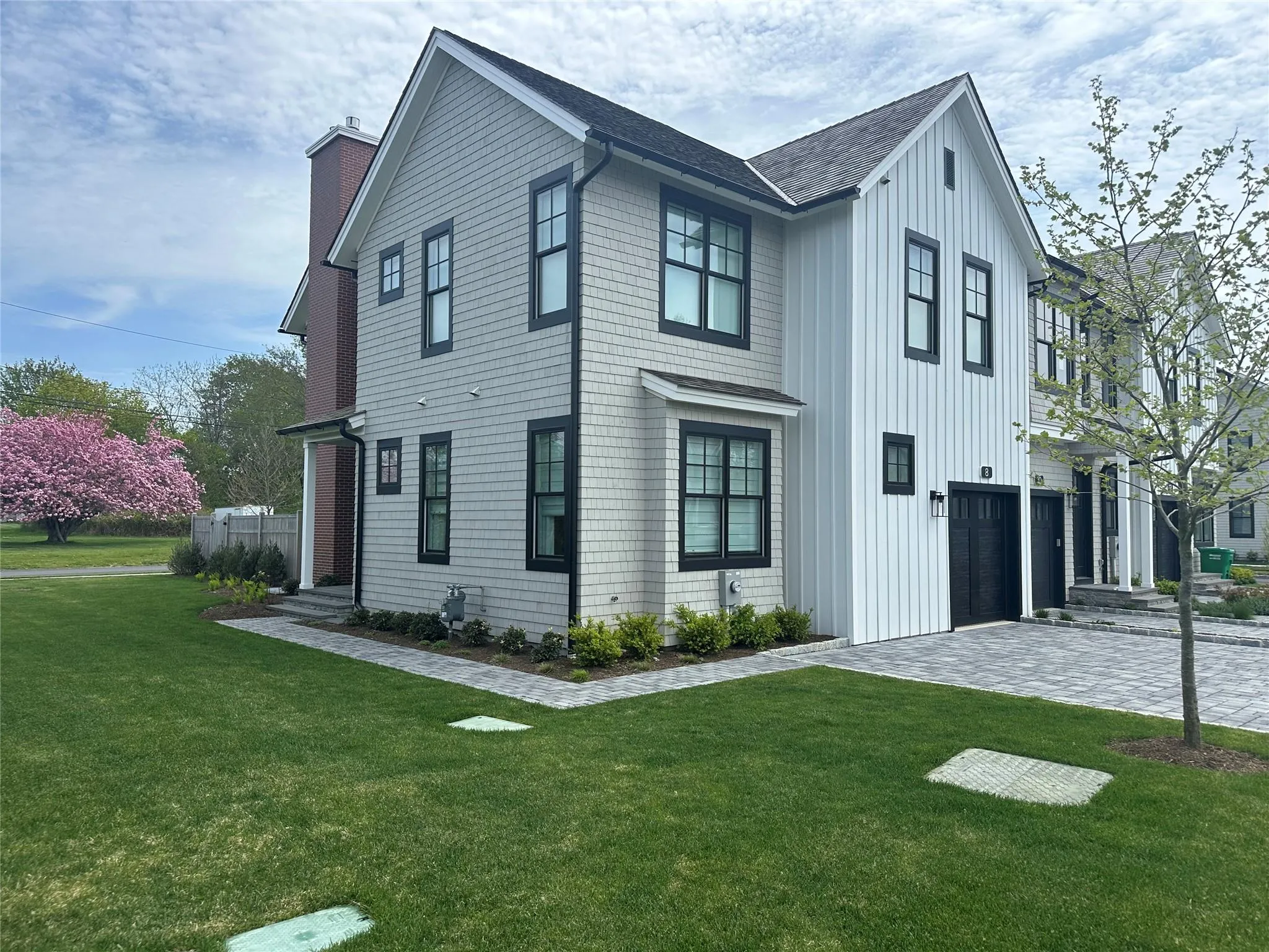 View of front of property featuring a chimney, a front yard, a garage, board and batten siding, and driveway View of front of property featuring a chimney, a front yard, a garage, board and batten siding, and driveway