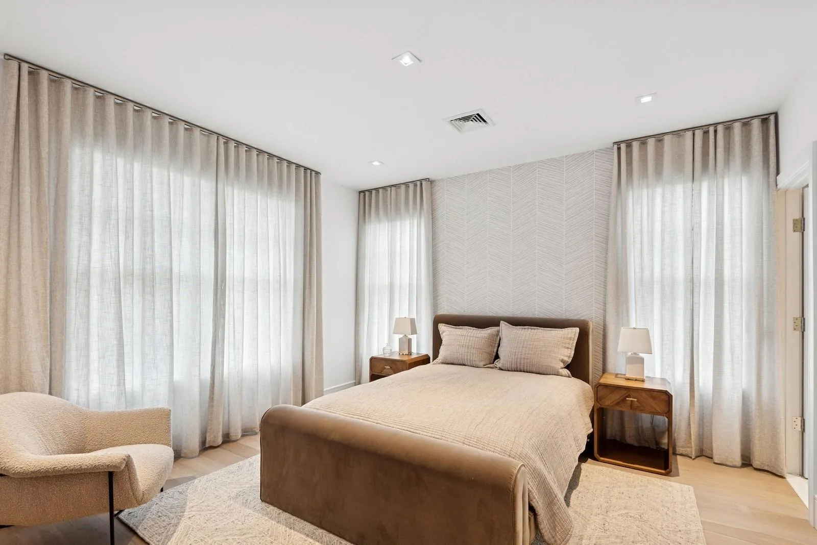 Bedroom featuring light wood-type flooring and wallpapered walls Bedroom featuring light wood-type flooring and wallpapered walls