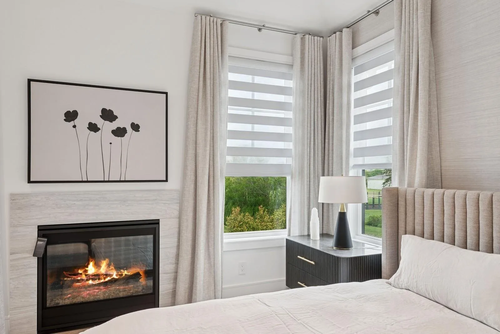 Bedroom with a glass covered fireplace and baseboards Bedroom with a glass covered fireplace and baseboards