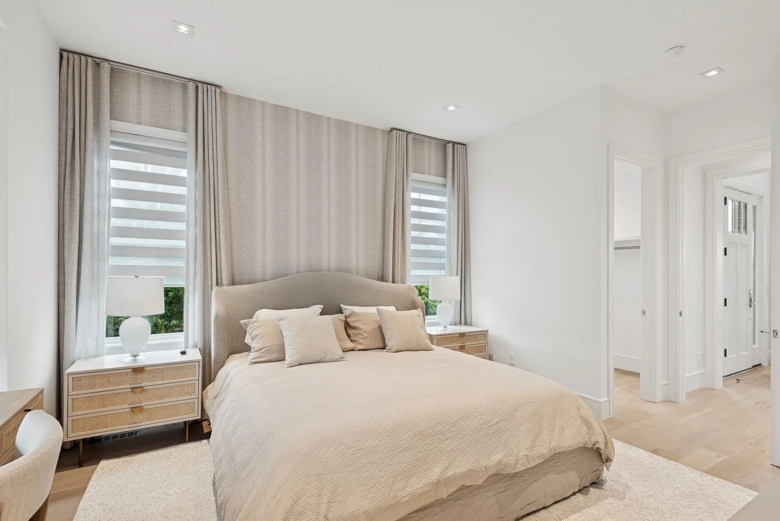 Bedroom with light wood-type flooring, multiple windows, recessed lighting, baseboards, and wallpapered walls Bedroom with light wood-type flooring, multiple windows, recessed lighting, baseboards, and wallpapered walls
