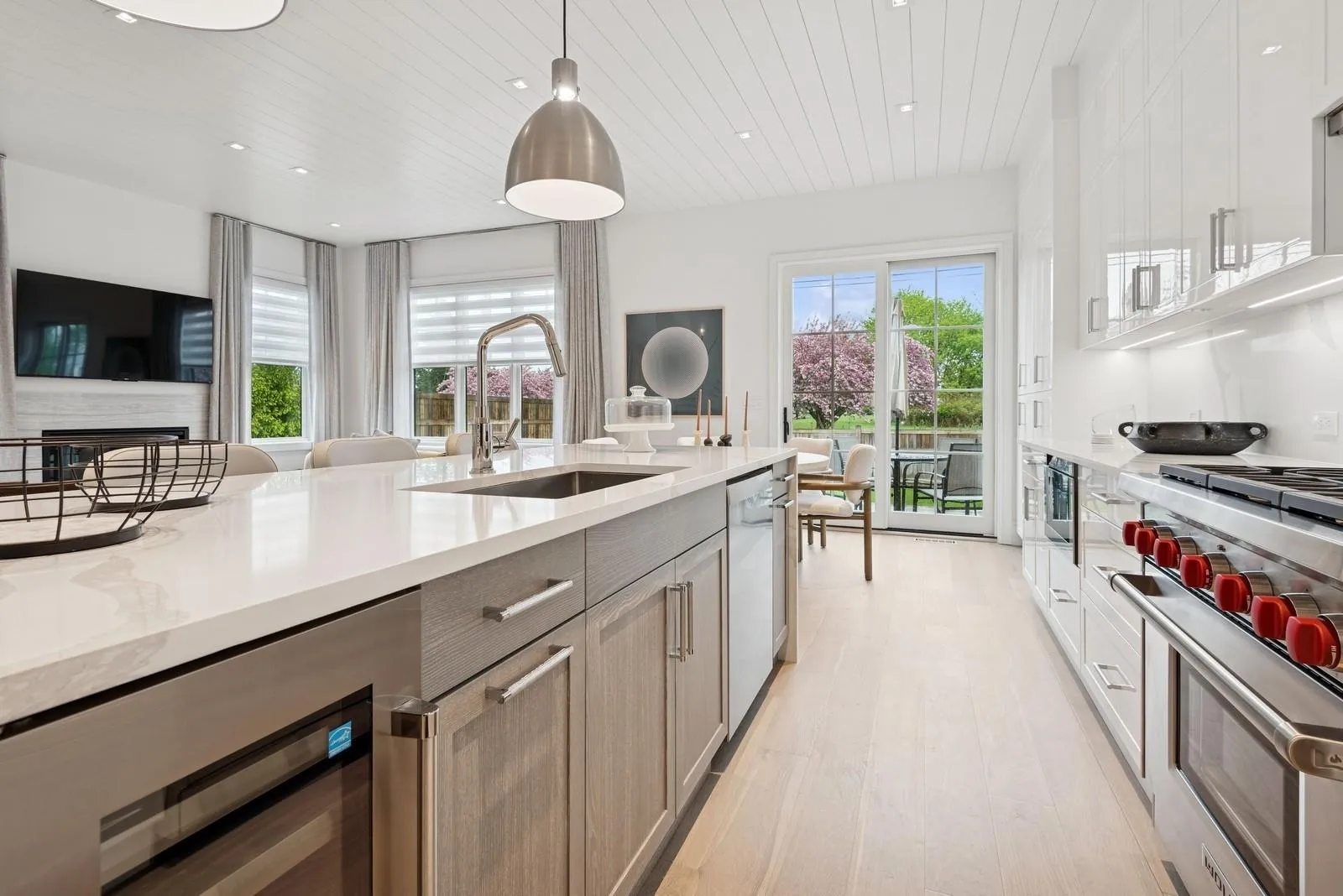 Kitchen with a sink, stainless steel appliances, beverage cooler, wood ceiling, and light wood-style flooring Kitchen with a sink, stainless steel appliances, beverage cooler, wood ceiling, and light wood-style flooring