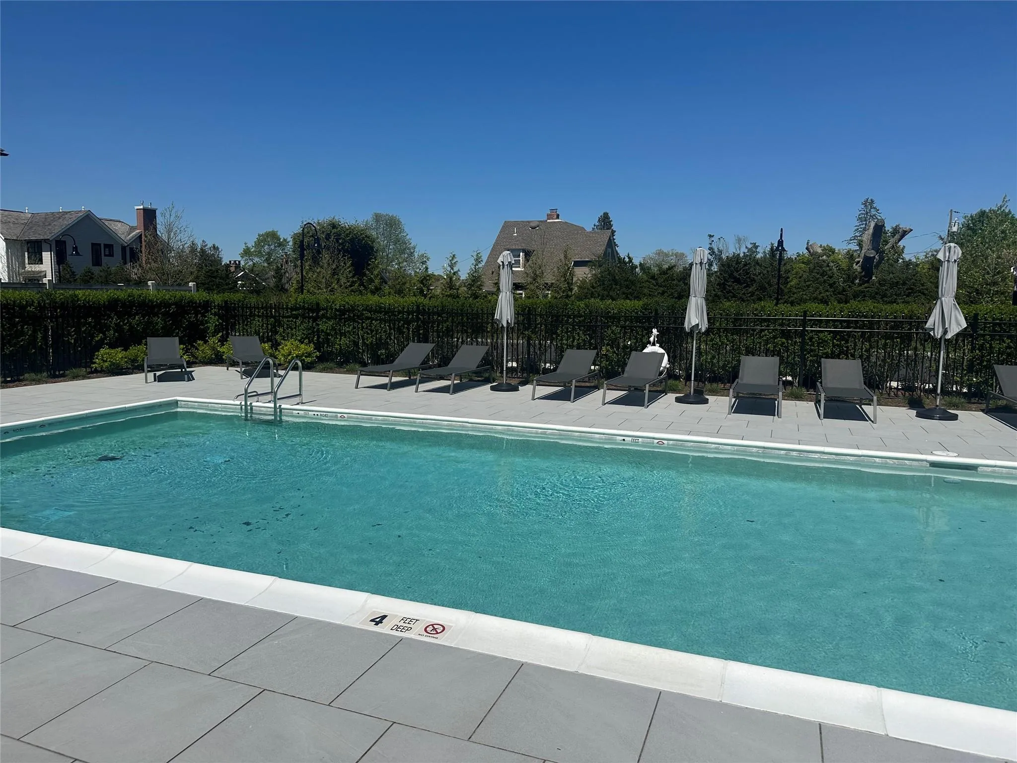 Community pool with fence and a patio Community pool with fence and a patio