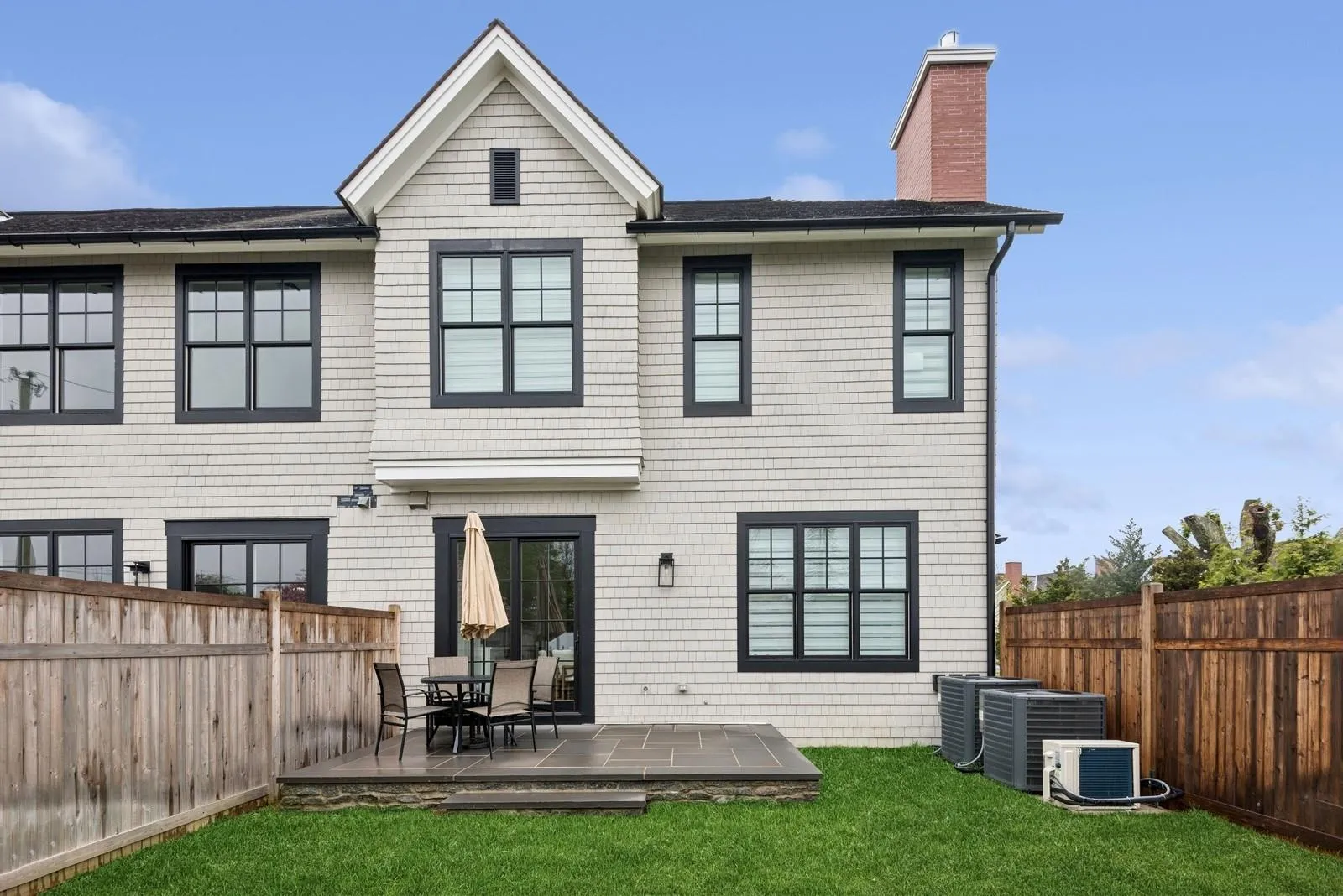Back of property with a chimney, a patio, roof with shingles, and central AC Back of property with a chimney, a patio, roof with shingles, and central AC