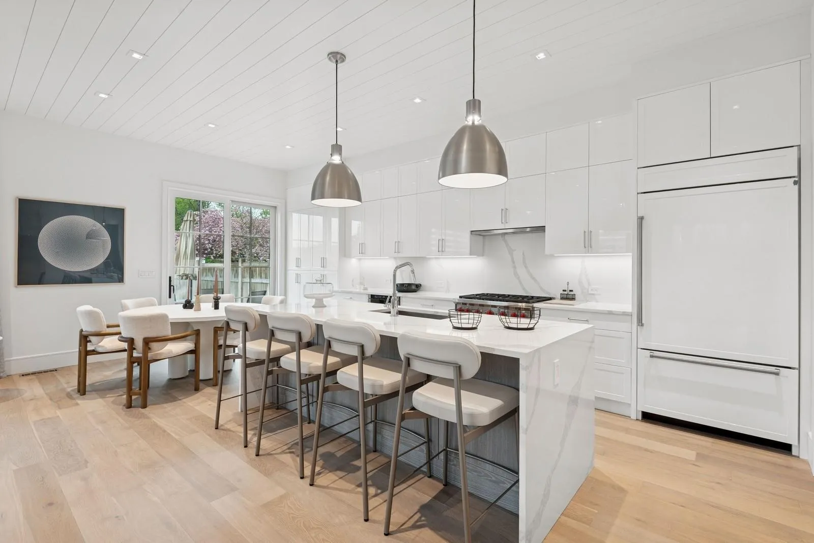 Kitchen with paneled built in fridge, a sink, light wood finished floors, white cabinets, and light countertops Kitchen with paneled built in fridge, a sink, light wood finished floors, white cabinets, and light countertops
