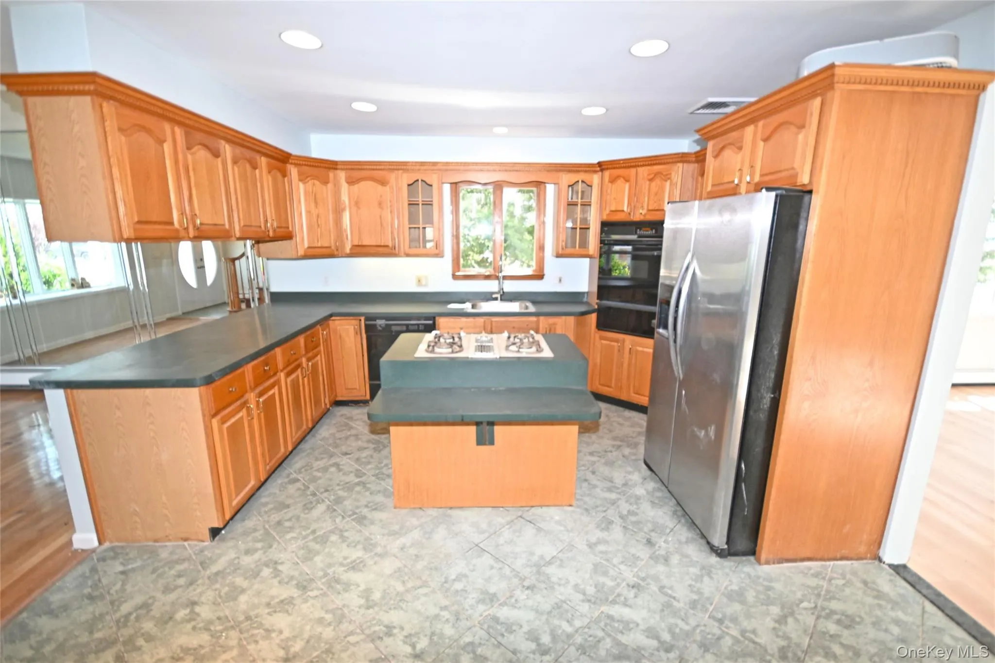 Kitchen with black appliances, plenty of natural light, a sink, dark countertops, and recessed lighting Kitchen with black appliances, plenty of natural light, a sink, dark countertops, and recessed lighting