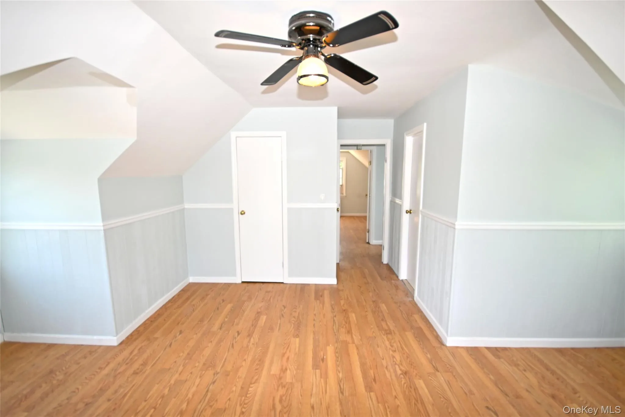 Additional living space with light wood-style flooring, a ceiling fan, baseboards, and lofted ceiling Additional living space with light wood-style flooring, a ceiling fan, baseboards, and lofted ceiling