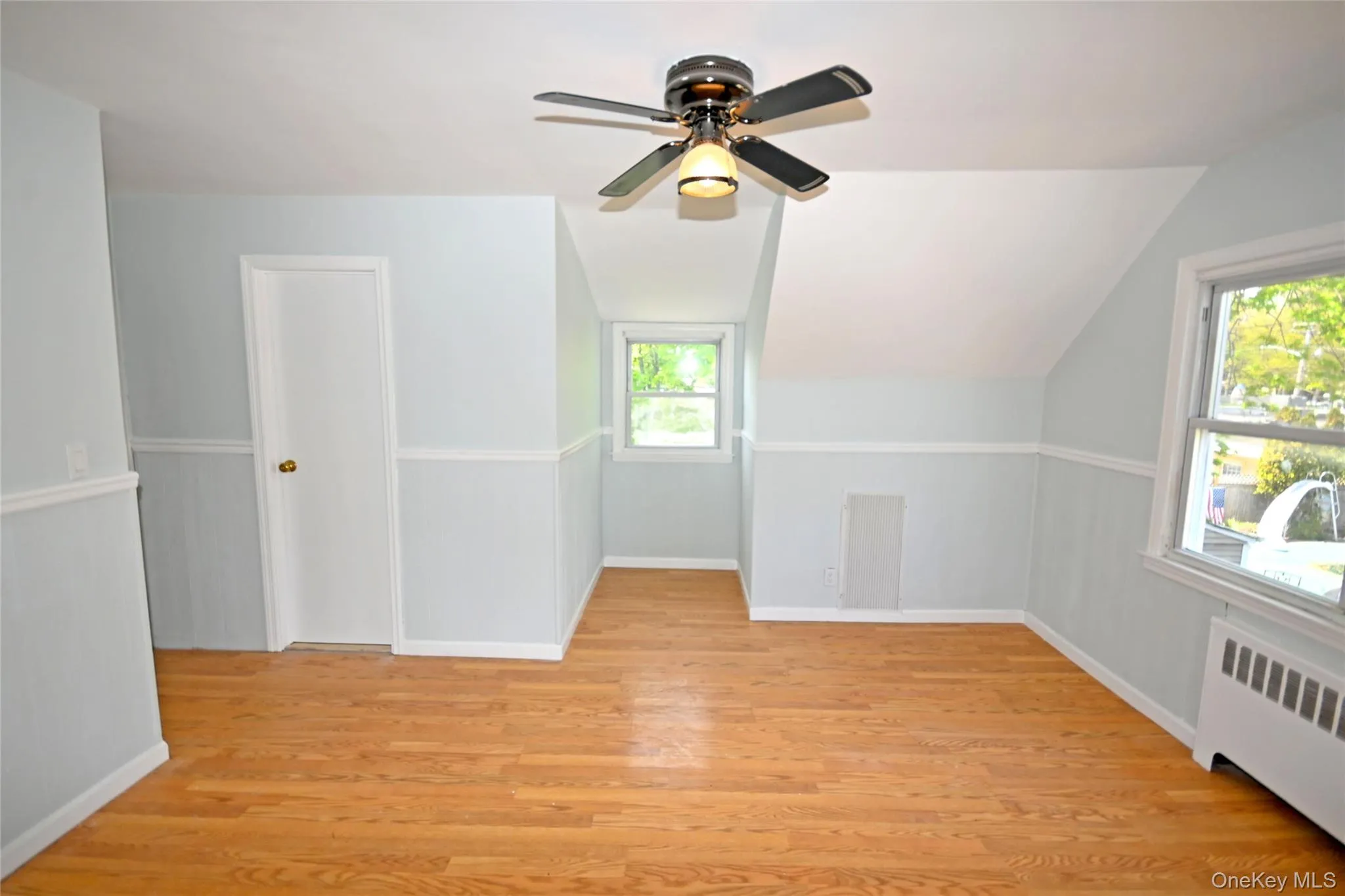 Bonus room with radiator, plenty of natural light, light wood finished floors, and lofted ceiling Bonus room with radiator, plenty of natural light, light wood finished floors, and lofted ceiling
