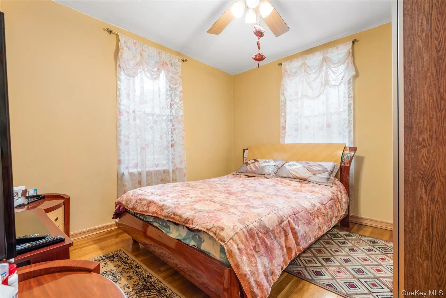 Bedroom with multiple windows, wood finished floors, and baseboards Bedroom with multiple windows, wood finished floors, and baseboards
