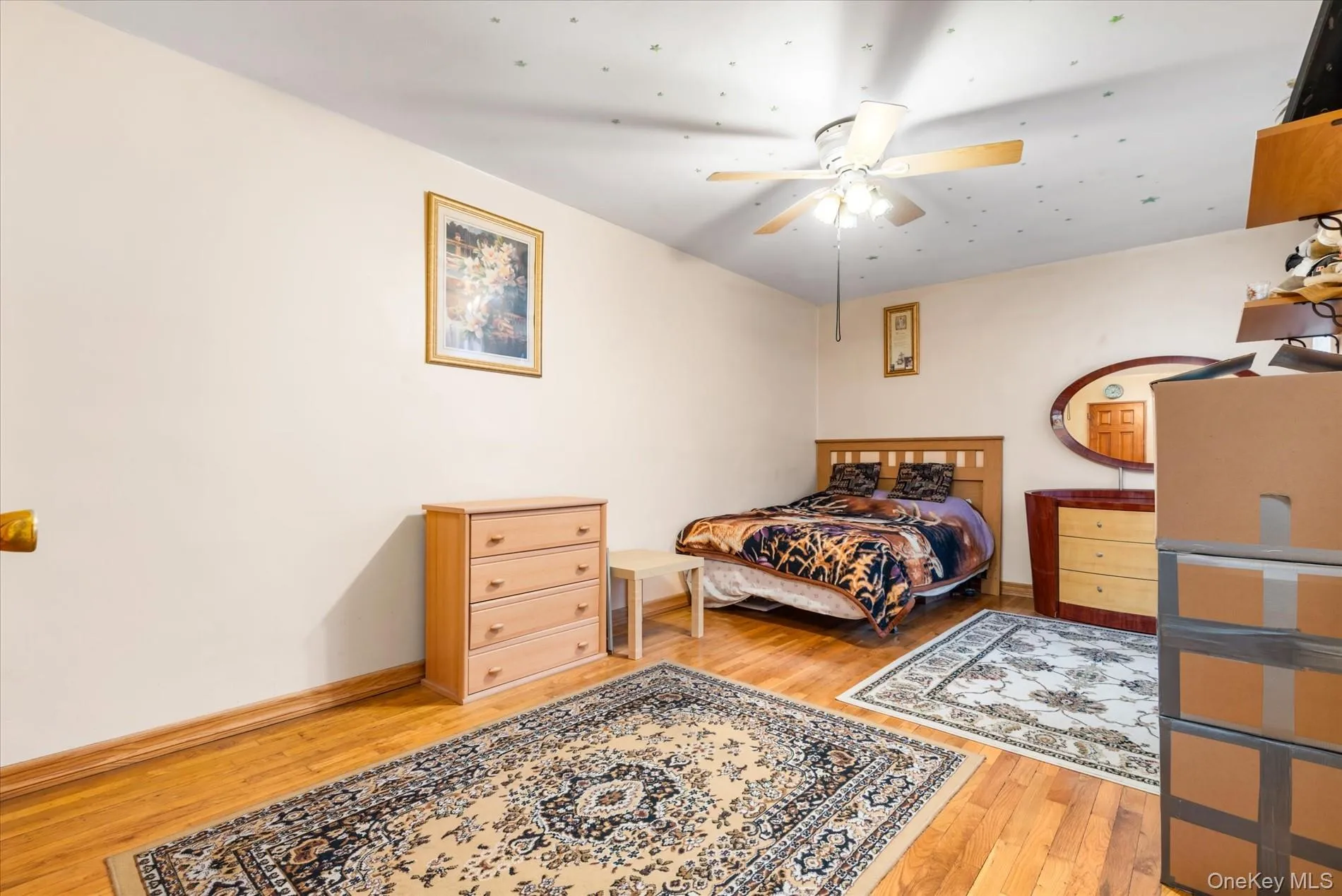 Bedroom featuring light wood finished floors, baseboards, and a ceiling fan Bedroom featuring light wood finished floors, baseboards, and a ceiling fan