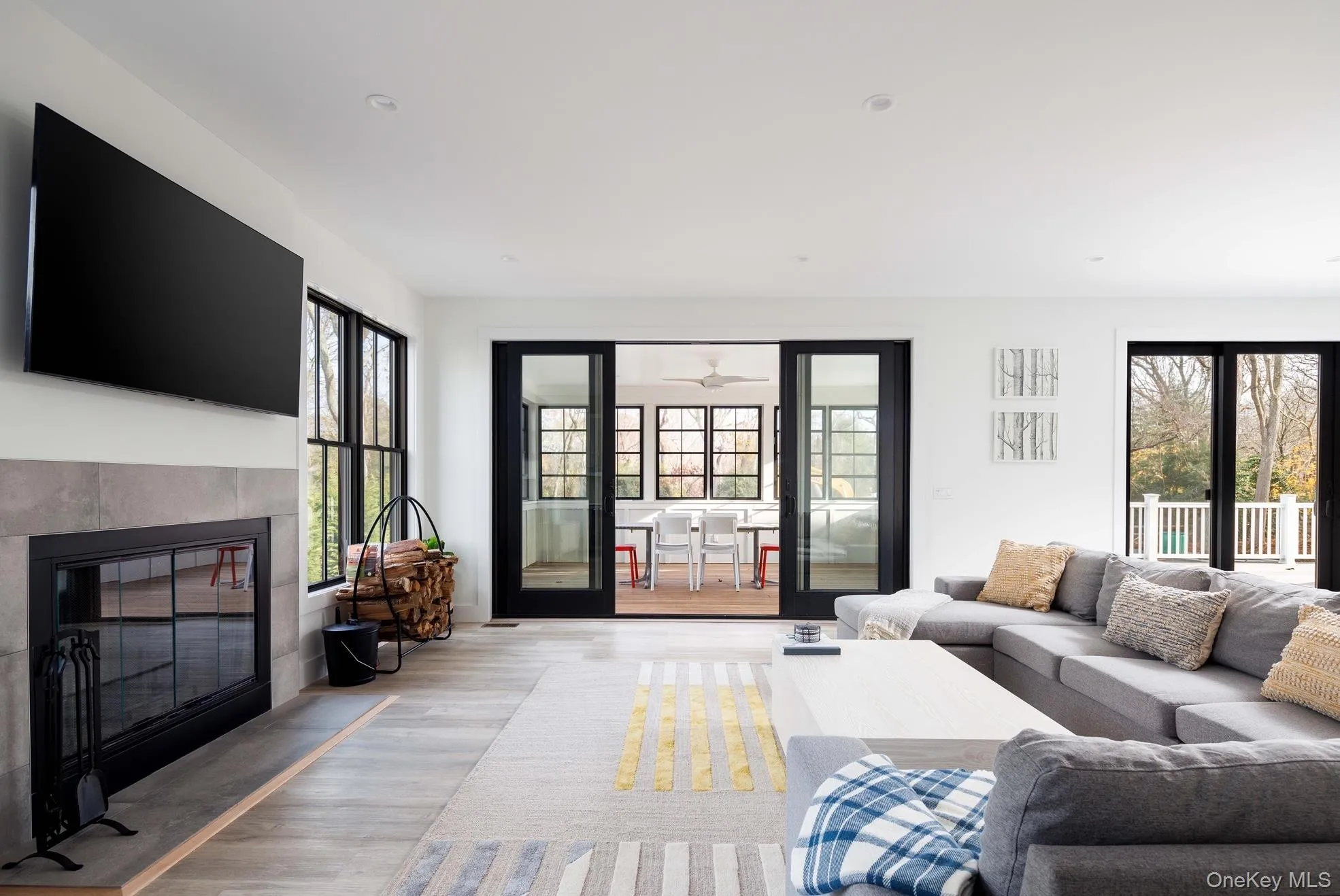 Living room featuring plenty of natural light, light wood-type flooring, a fireplace, and ceiling fan Living room featuring plenty of natural light, light wood-type flooring, a fireplace, and ceiling fan