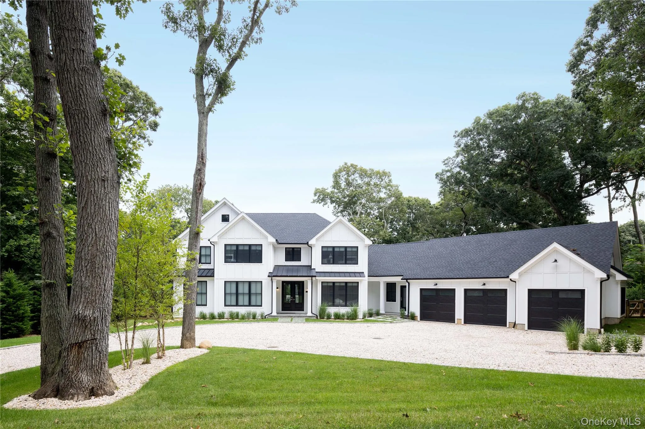 Modern farmhouse style home with board and batten siding, an attached garage, driveway, a front lawn, and a shingled roof Modern farmhouse style home with board and batten siding, an attached garage, driveway, a front lawn, and a shingled roof