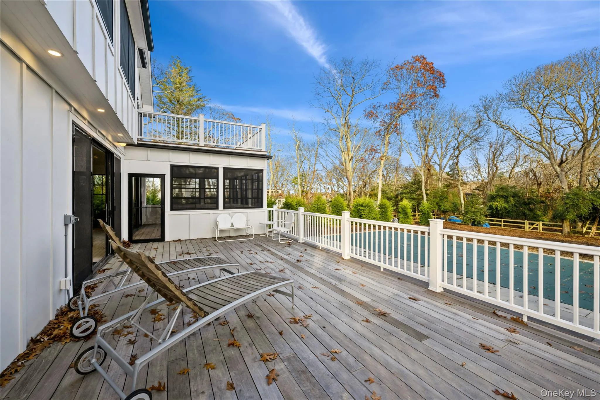 Wooden terrace featuring a sunroom and a pool Wooden terrace featuring a sunroom and a pool