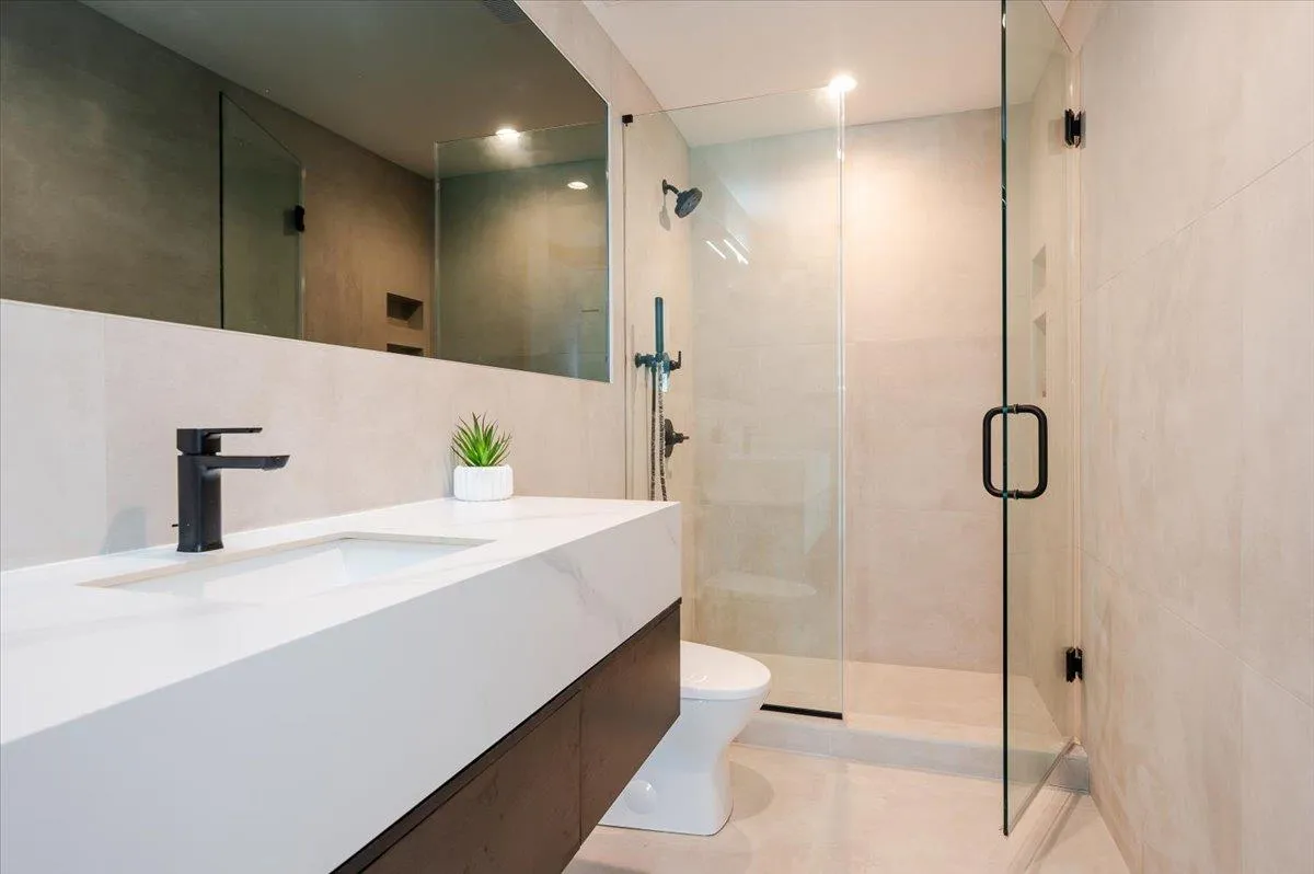 Full bathroom with a stall shower, toilet, vanity, tile patterned flooring, and recessed lighting Full bathroom with a stall shower, toilet, vanity, tile patterned flooring, and recessed lighting