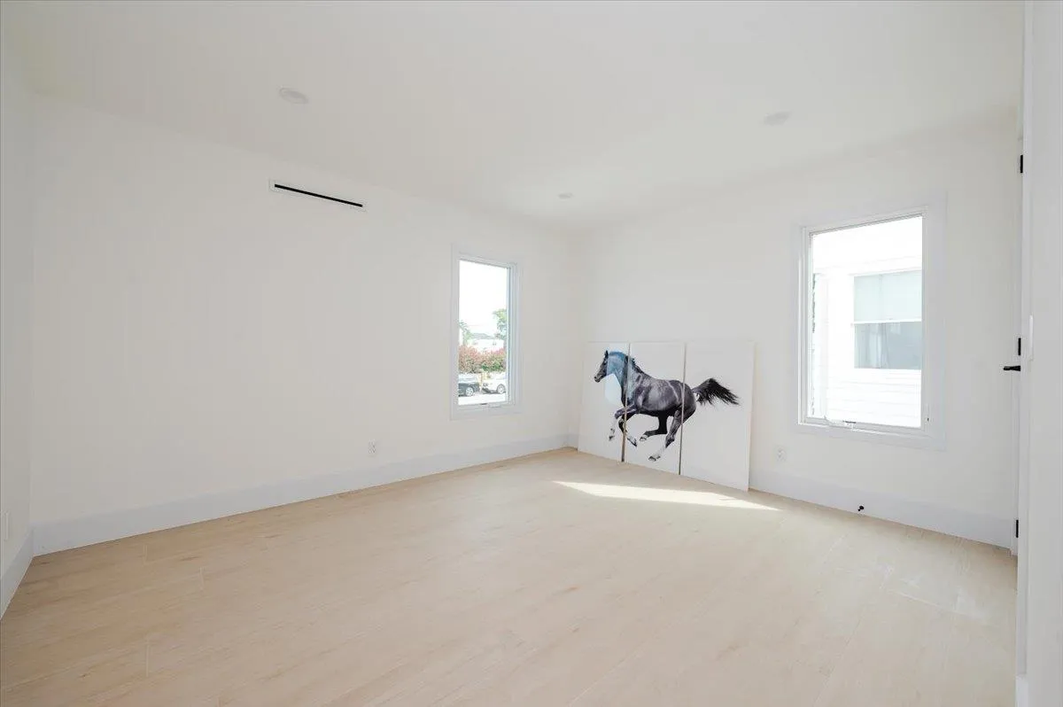 Empty room featuring healthy amount of natural light, light wood finished floors, and baseboards Empty room featuring healthy amount of natural light, light wood finished floors, and baseboards