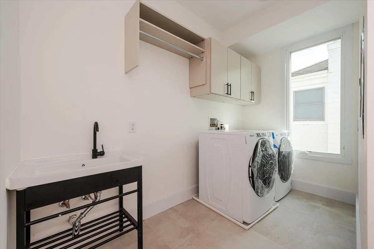 Clothes washing area with washing machine and dryer, cabinet space, and baseboards Clothes washing area with washing machine and dryer, cabinet space, and baseboards