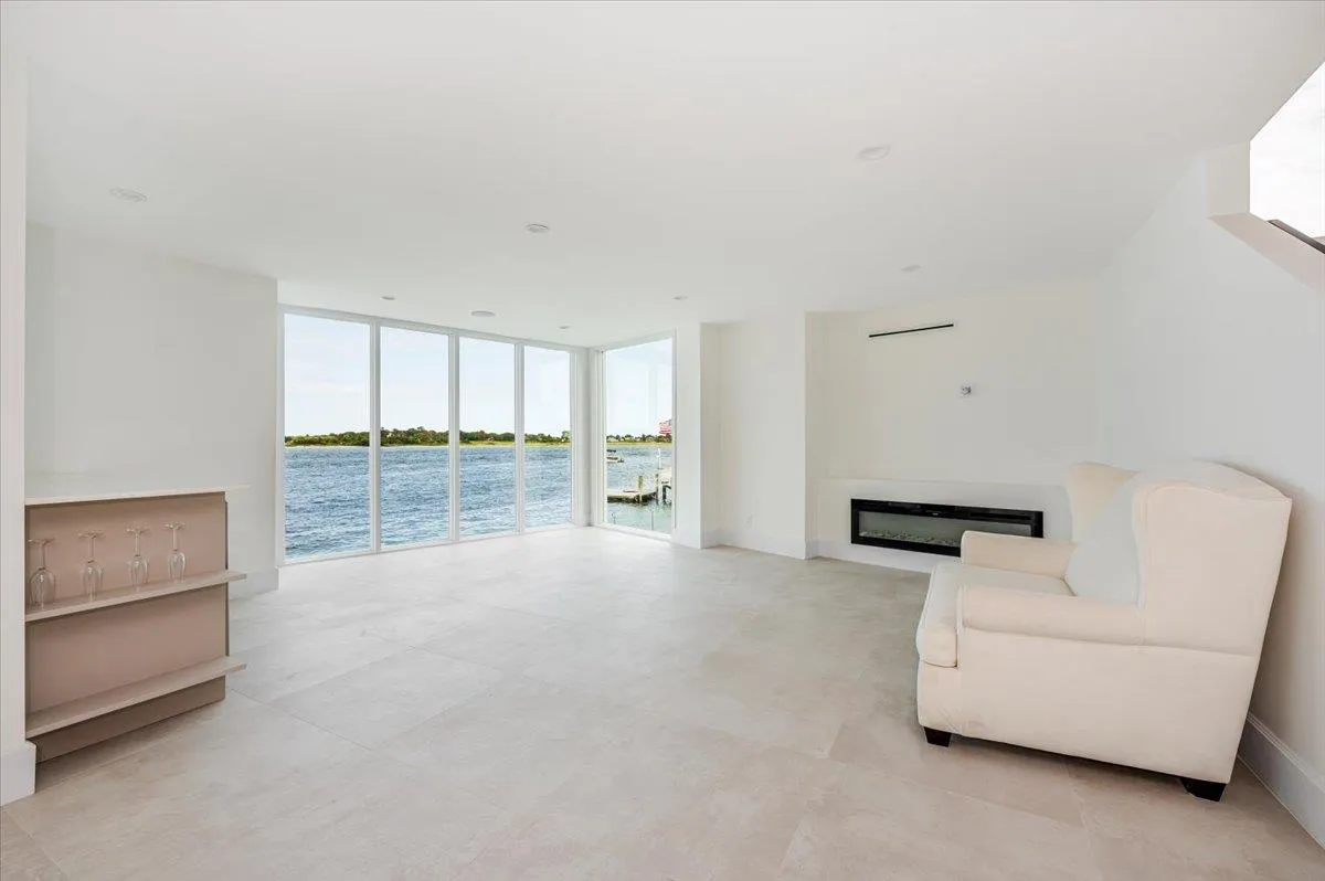 Living area with floor to ceiling windows, a water view, and a glass covered fireplace Living area with floor to ceiling windows, a water view, and a glass covered fireplace