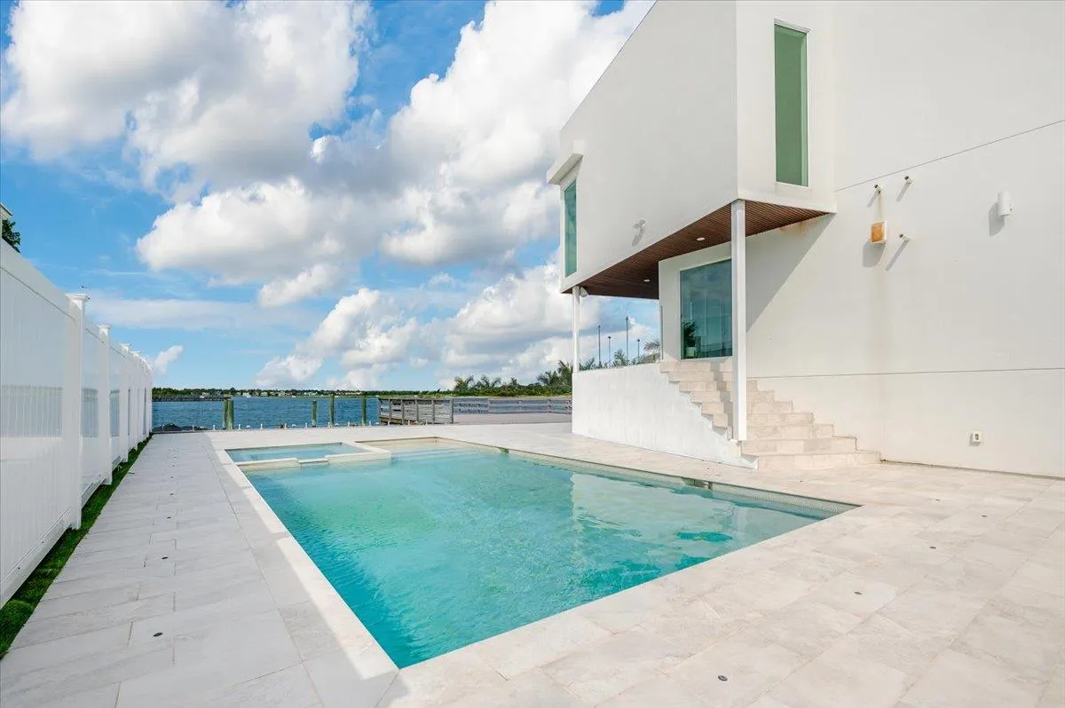 View of pool featuring a patio, stairway, and a pool with connected hot tub View of pool featuring a patio, stairway, and a pool with connected hot tub
