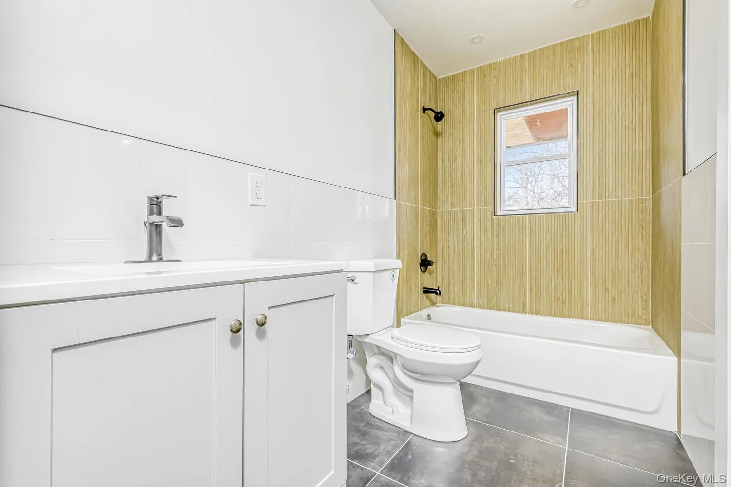 Bathroom with shower / bathtub combination, tile walls, toilet, tile patterned floors, and vanity Bathroom with shower / bathtub combination, tile walls, toilet, tile patterned floors, and vanity