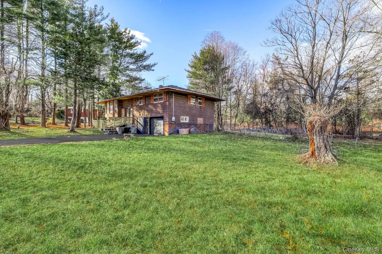View of green lawn with asphalt driveway and an attached garage View of green lawn with asphalt driveway and an attached garage