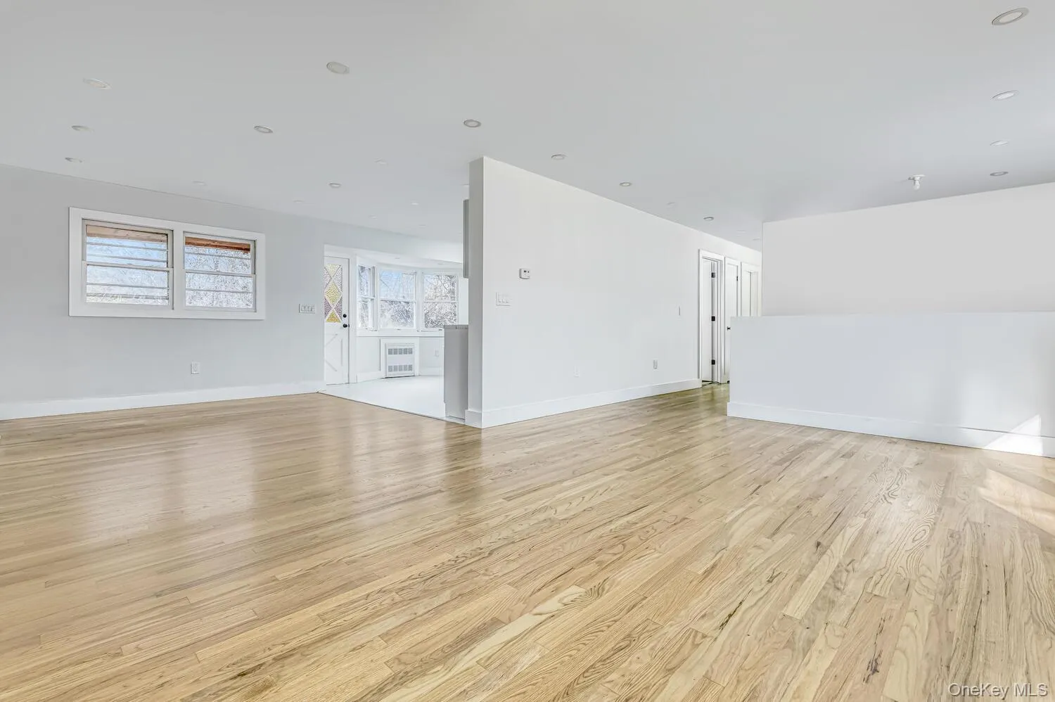 Unfurnished living room featuring light wood-style floors and baseboards Unfurnished living room featuring light wood-style floors and baseboards