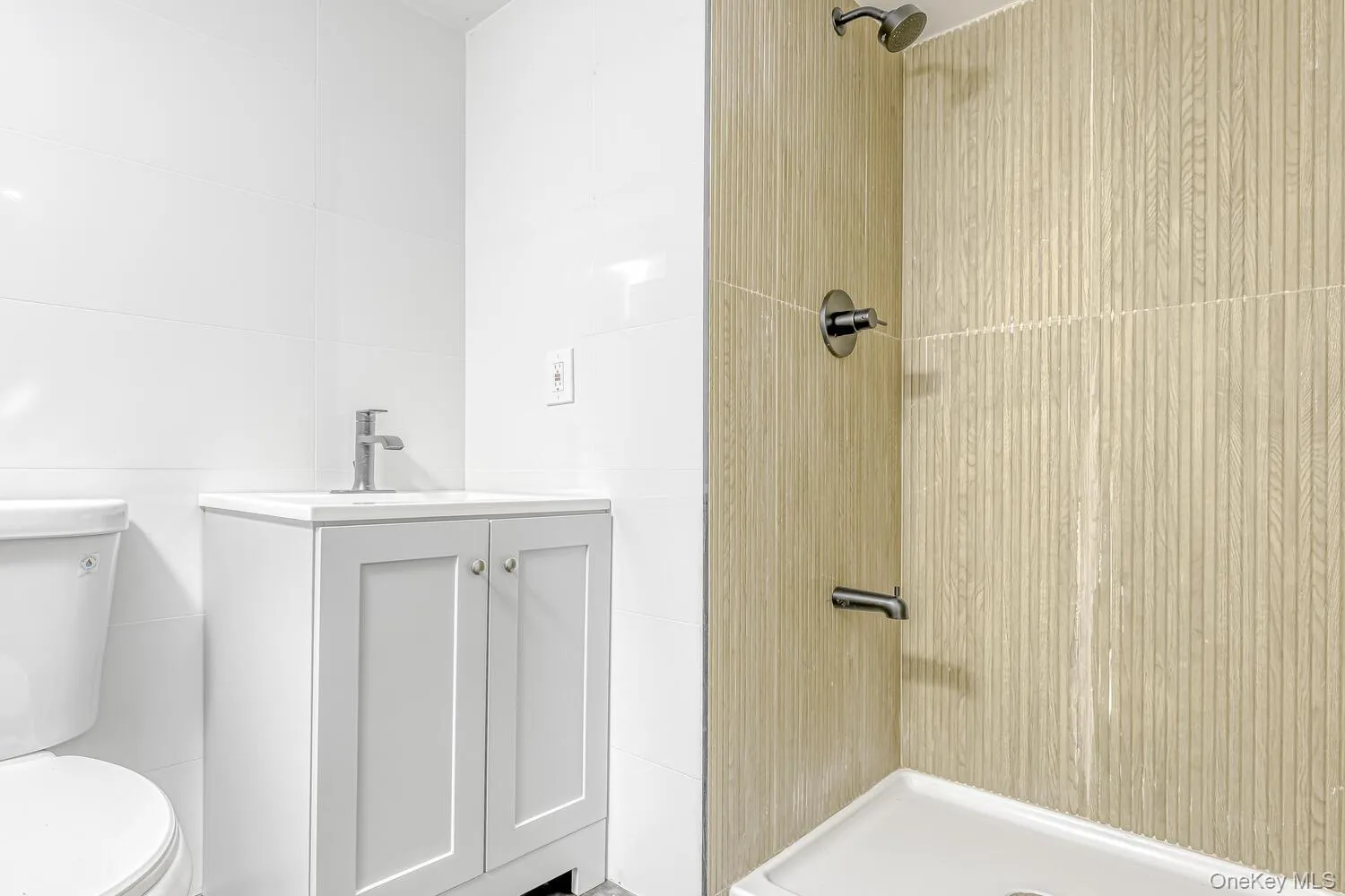 Bathroom featuring a shower stall, tile walls, toilet, and vanity Bathroom featuring a shower stall, tile walls, toilet, and vanity