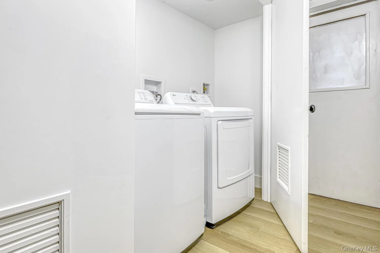 Laundry area featuring washing machine and clothes dryer and light wood finished floors Laundry area featuring washing machine and clothes dryer and light wood finished floors