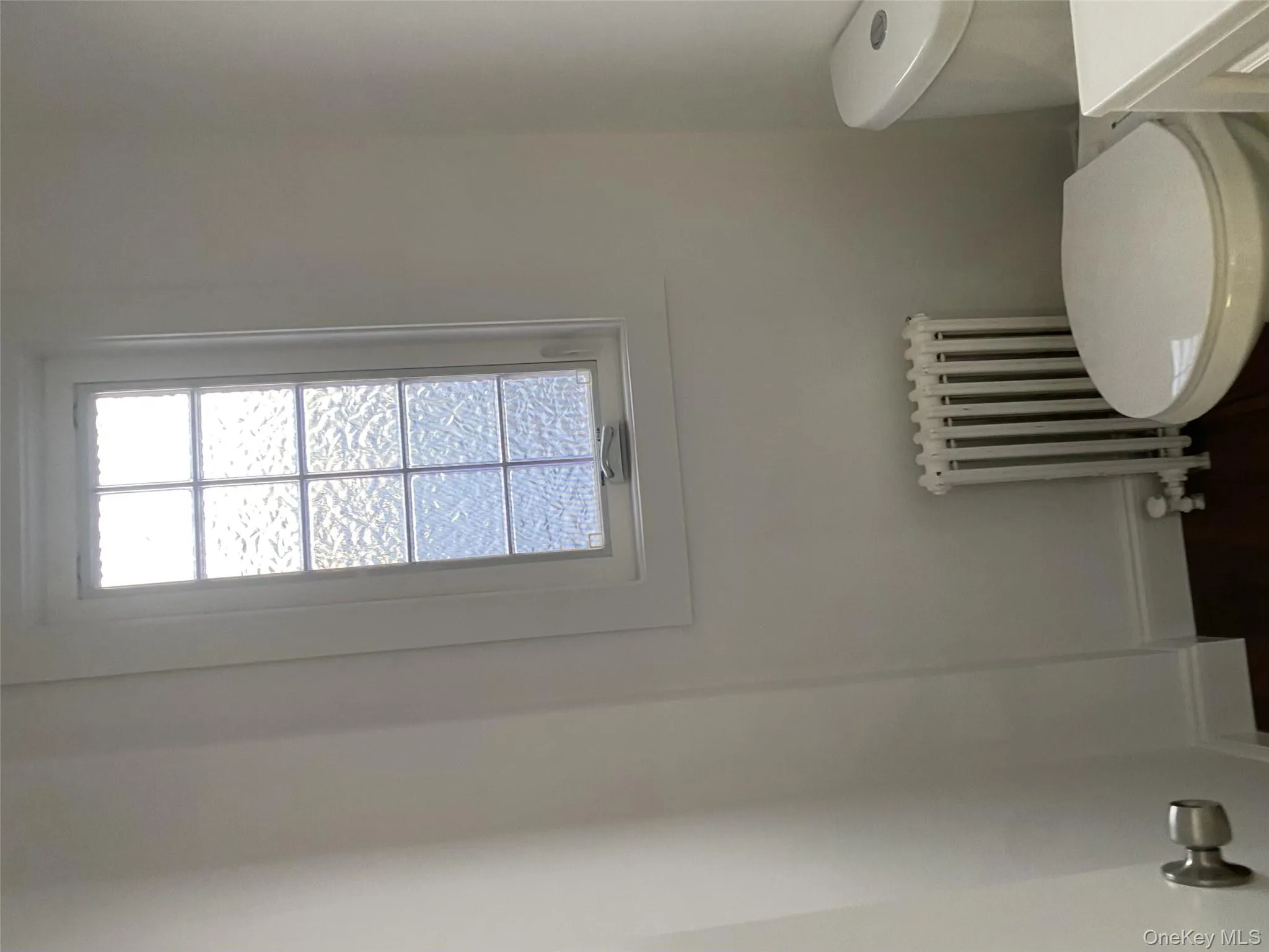 Bathroom featuring radiator, toilet, and plenty of natural light Bathroom featuring radiator, toilet, and plenty of natural light
