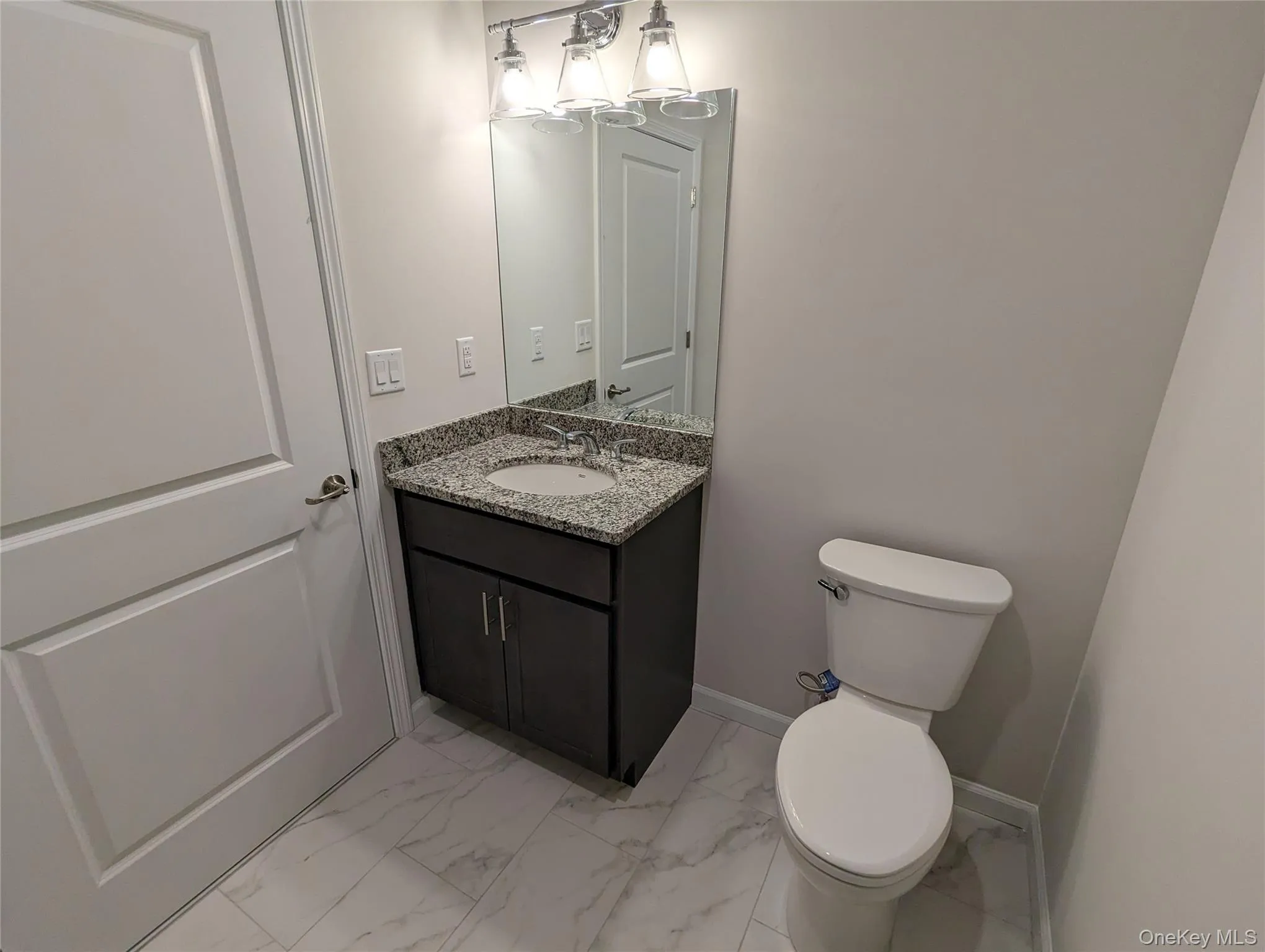 2nd bathroom with marble look tiles, toilet, vanity, and baseboards 2nd bathroom with marble look tiles, toilet, vanity, and baseboards