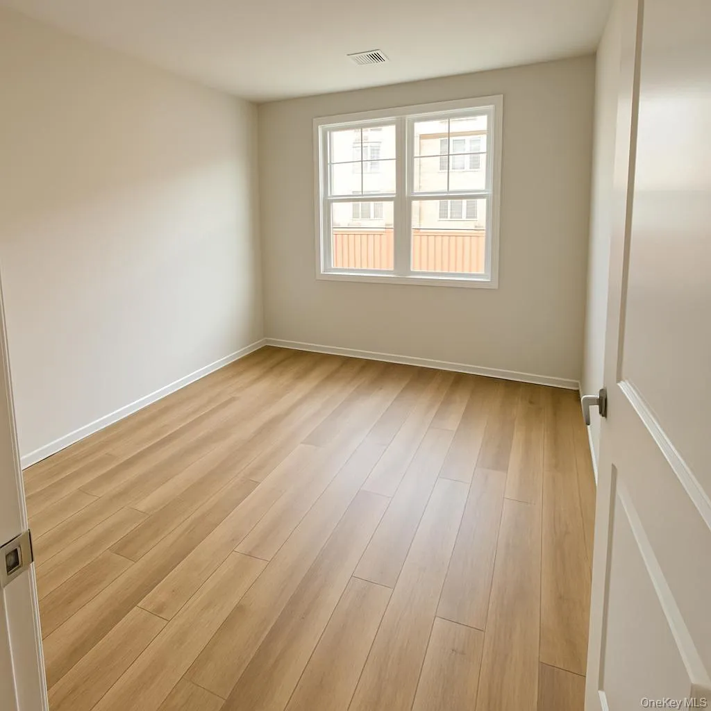 Unfurnished room with light wood finished floors and baseboards Unfurnished room with light wood finished floors and baseboards