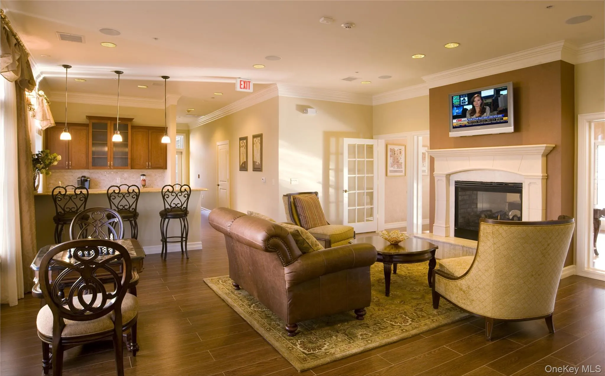 Living room featuring recessed lighting, dark wood finished floors, a glass covered fireplace, and baseboards Living room featuring recessed lighting, dark wood finished floors, a glass covered fireplace, and baseboards