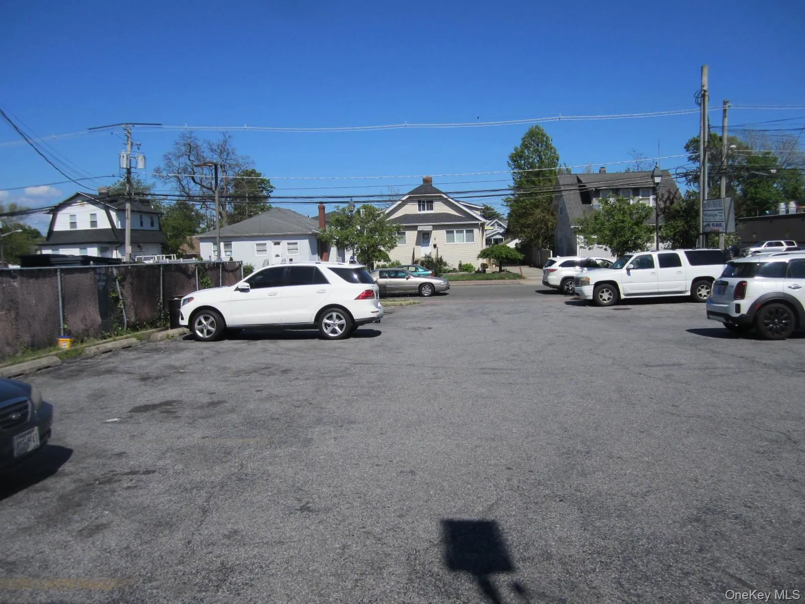 Uncovered parking lot with fence and a residential view Uncovered parking lot with fence and a residential view