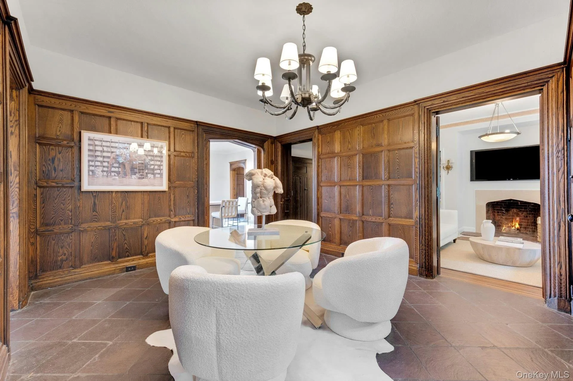Sitting space with a chandelier and a lit fireplace Sitting space with a chandelier and a lit fireplace