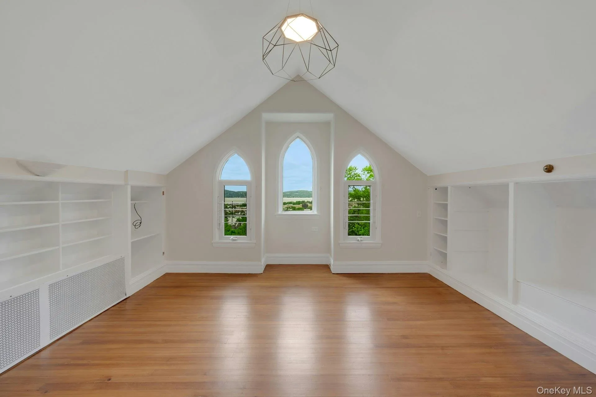 Bonus room (top level bedroom) featuring built in features, light wood-type flooring, vaulted ceiling, and baseboards. Additional bedroom Bonus room (top level bedroom) featuring built in features, light wood-type flooring, vaulted ceiling, and baseboards. Additional bedroom