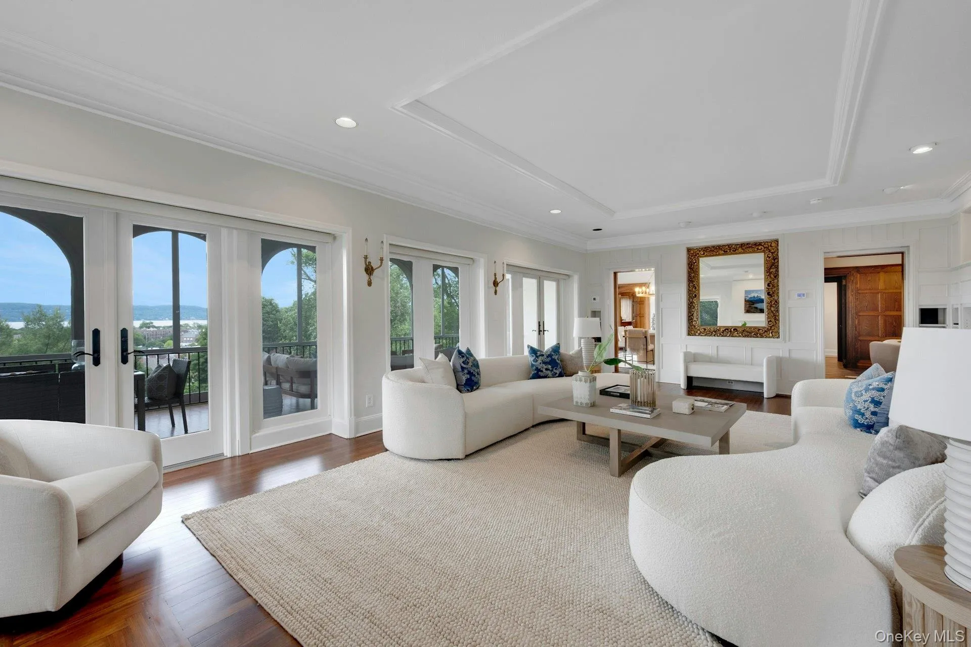 Living room with a raised ceiling, french doors, recessed lighting, ornamental molding, and dark wood-style floors Living room with a raised ceiling, french doors, recessed lighting, ornamental molding, and dark wood-style floors