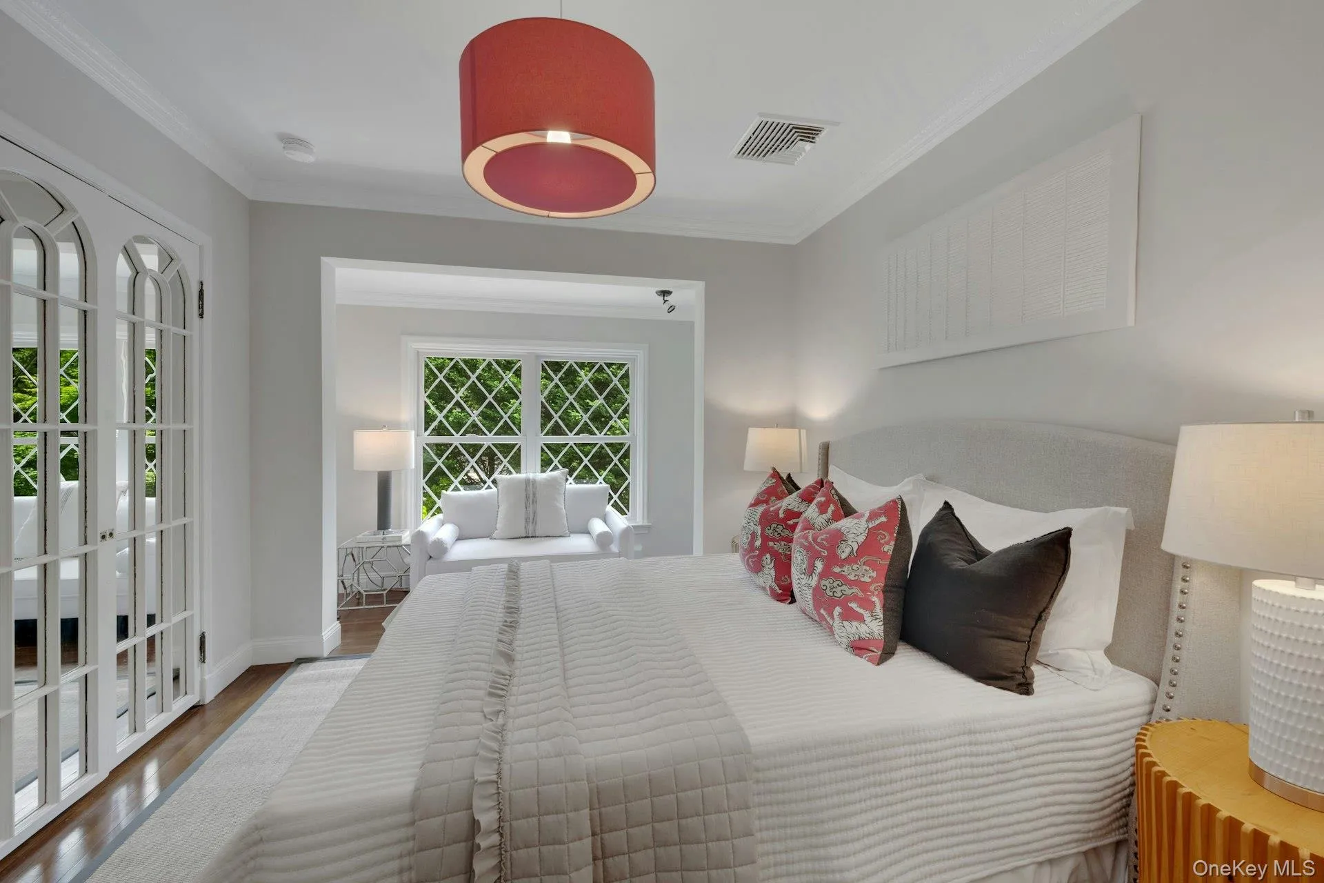 Bedroom with wood finished floors, crown molding, baseboards, and french doors Bedroom with wood finished floors, crown molding, baseboards, and french doors