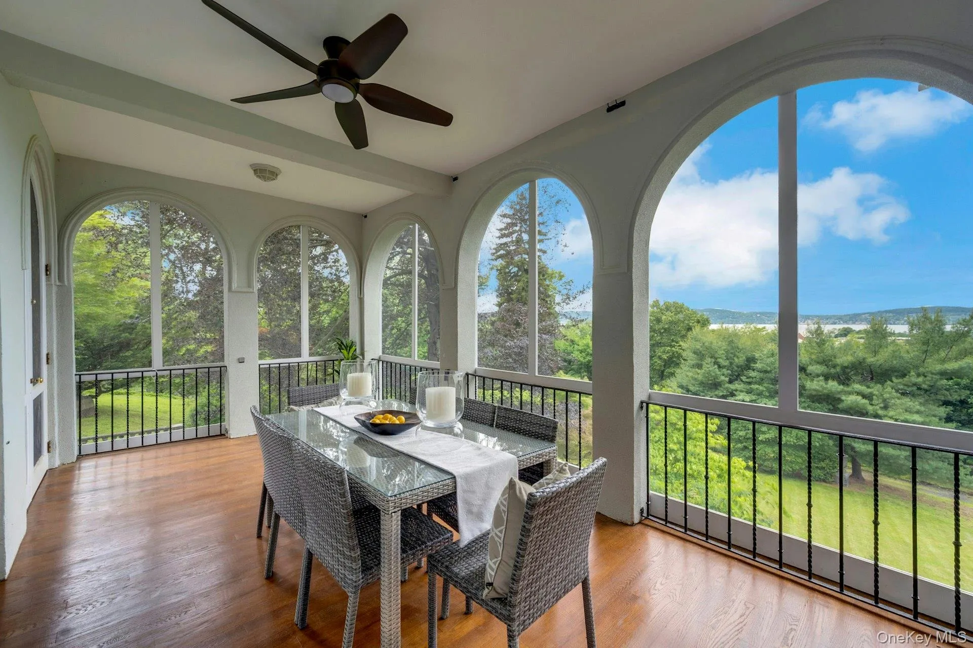 Sunroom / solarium with ceiling fan, outdoor dining area, and wood finished floors Sunroom / solarium with ceiling fan, outdoor dining area, and wood finished floors
