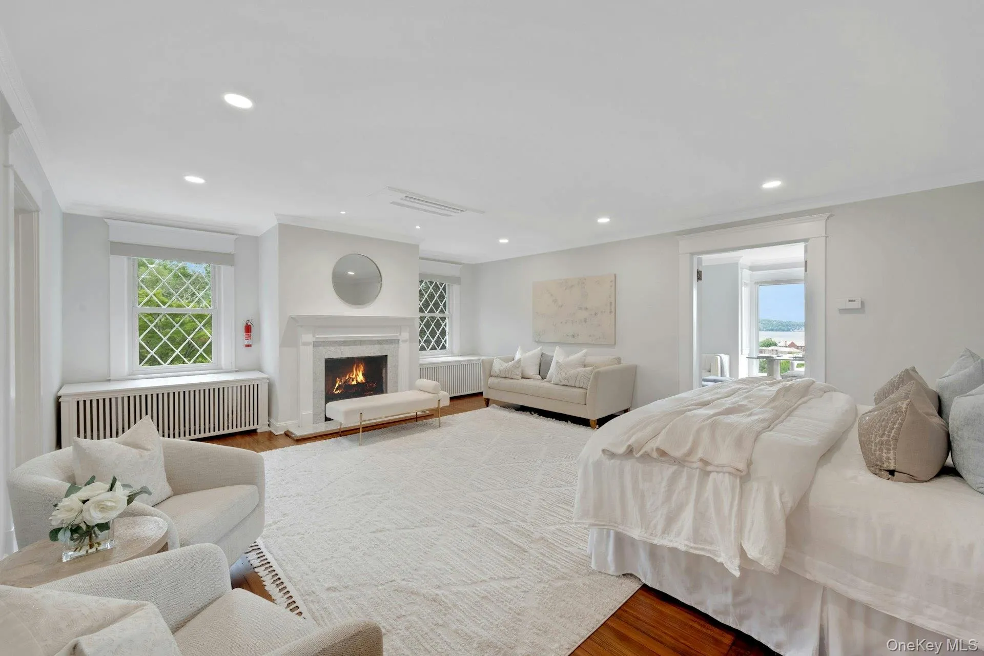Primary Bedroom suite featuring crown molding, multiple windows, wood finished floors, recessed lighting, and radiator Primary Bedroom suite featuring crown molding, multiple windows, wood finished floors, recessed lighting, and radiator