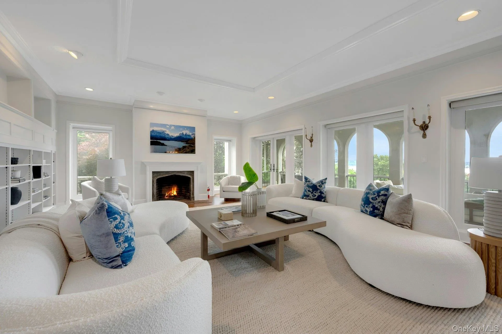 Living area featuring a tray ceiling, ornamental molding, recessed lighting, and a high end fireplace and Hudson River views Living area featuring a tray ceiling, ornamental molding, recessed lighting, and a high end fireplace and Hudson River views