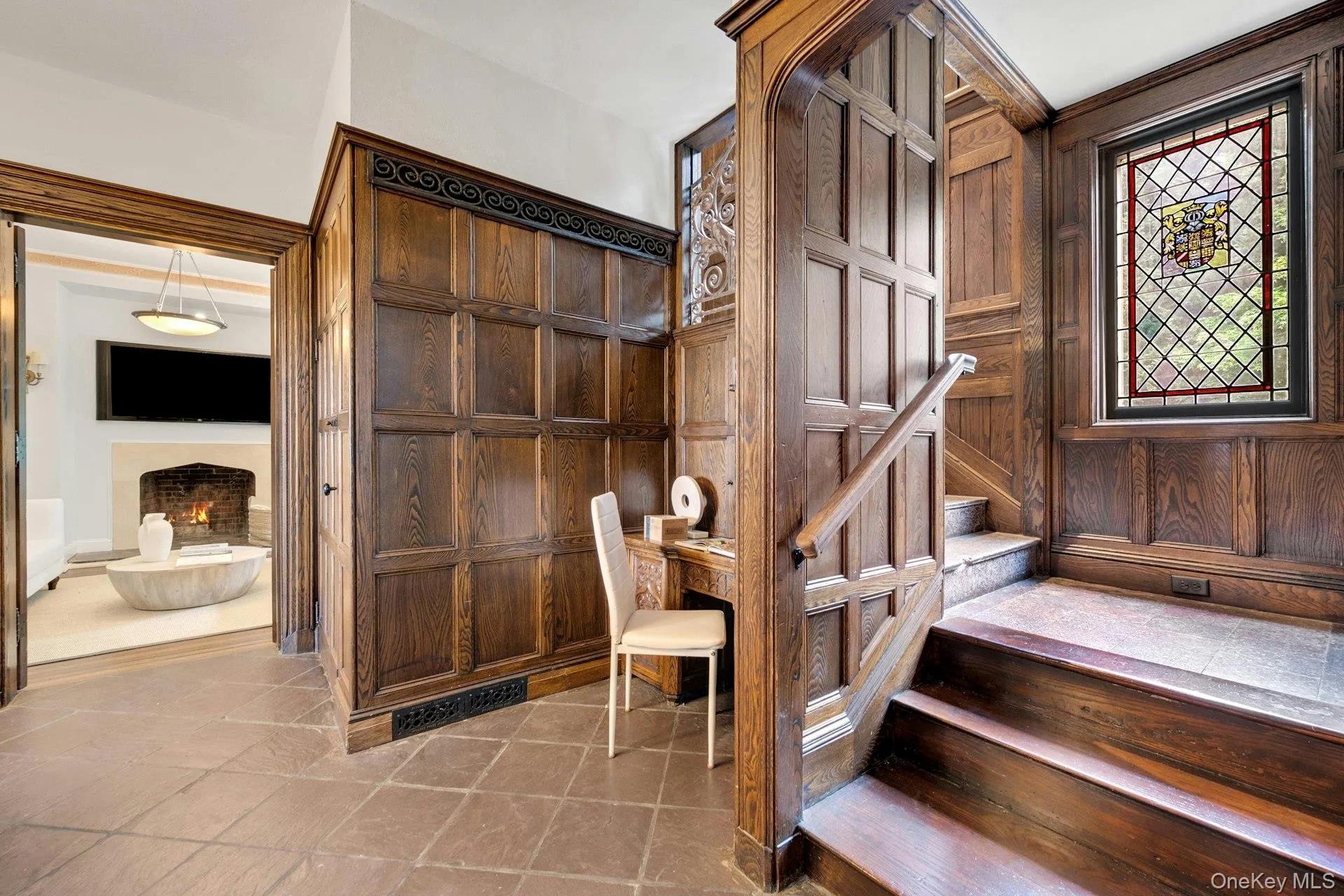 Stairway featuring a warm lit fireplace and exquisite detailed wooden walls Stairway featuring a warm lit fireplace and exquisite detailed wooden walls