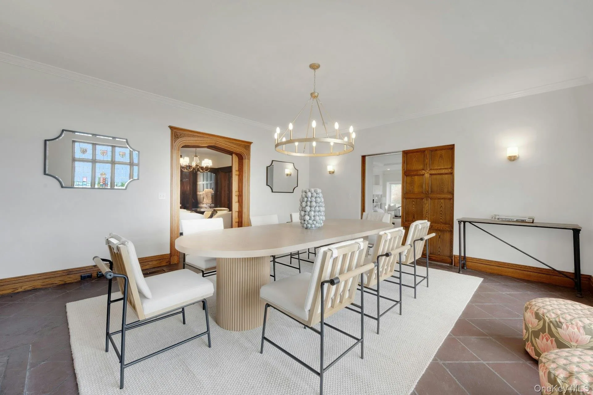 Formal dining space featuring a chandelier, ornamental molding, baseboards, and dark tile patterned floors Formal dining space featuring a chandelier, ornamental molding, baseboards, and dark tile patterned floors