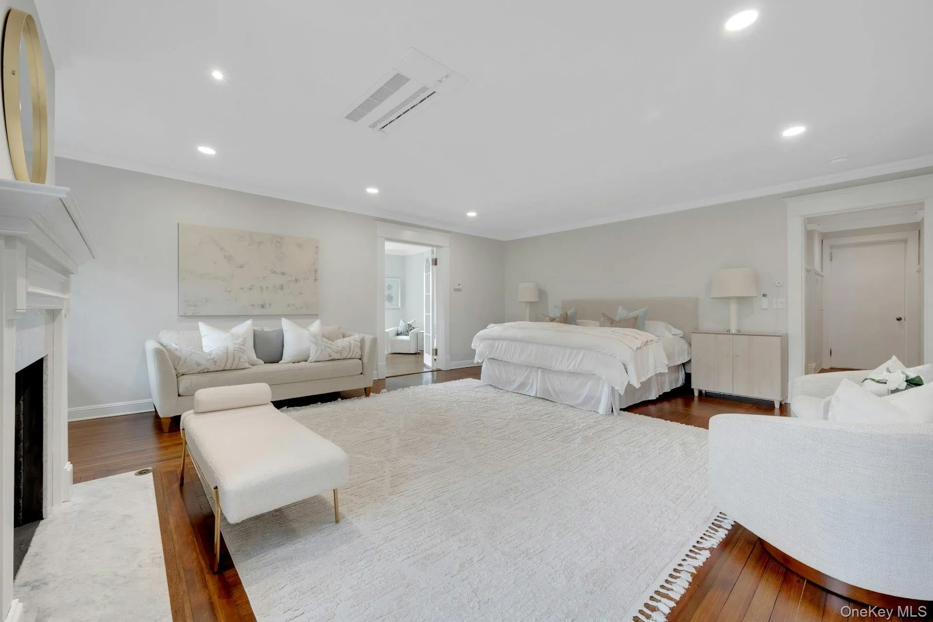 Primary Bedroom suite with recessed lighting, wood finished floors, baseboards, ornamental molding, and a fireplace with flush hearth Primary Bedroom suite with recessed lighting, wood finished floors, baseboards, ornamental molding, and a fireplace with flush hearth