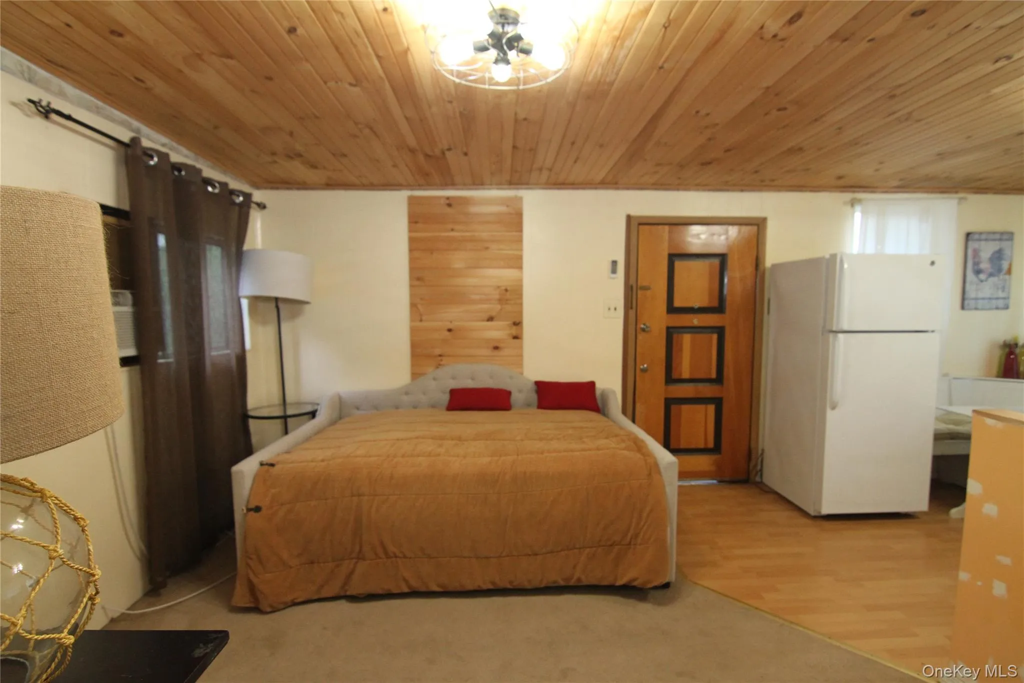 Bedroom featuring freestanding refrigerator and wood ceiling Bedroom featuring freestanding refrigerator and wood ceiling